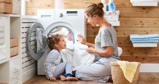 Textilpflege für das Bett - Mutter und Tochter vor der Waschmaschine