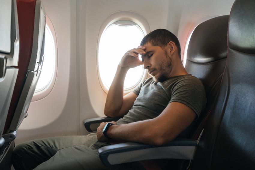 Mann hat Schwierigkeiten, im Flugzeug zu schlafen