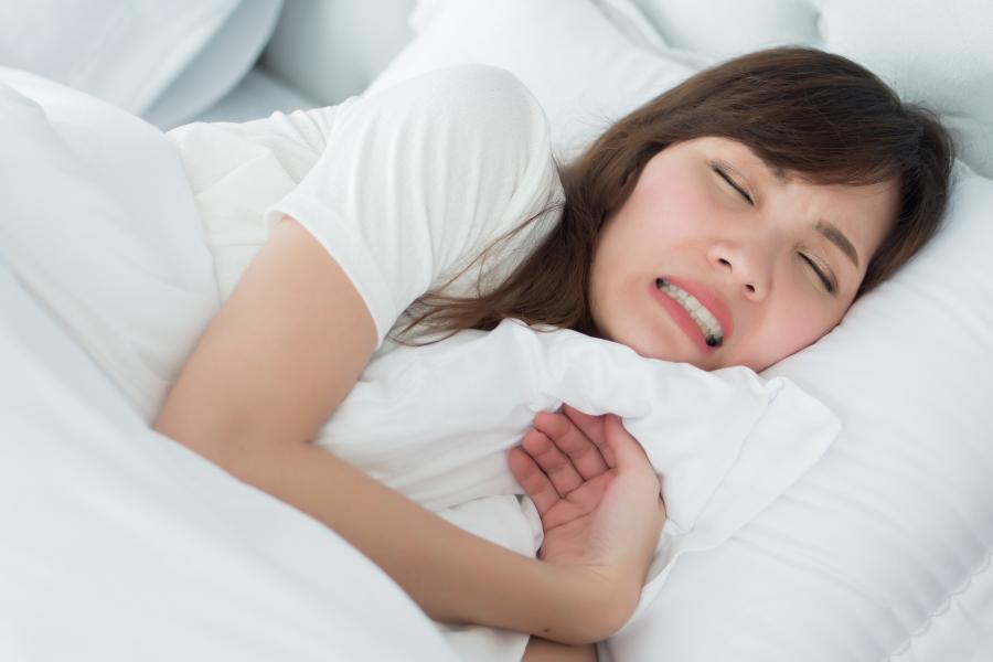 Frau knirscht im Schlaf mit ihren Zähnen