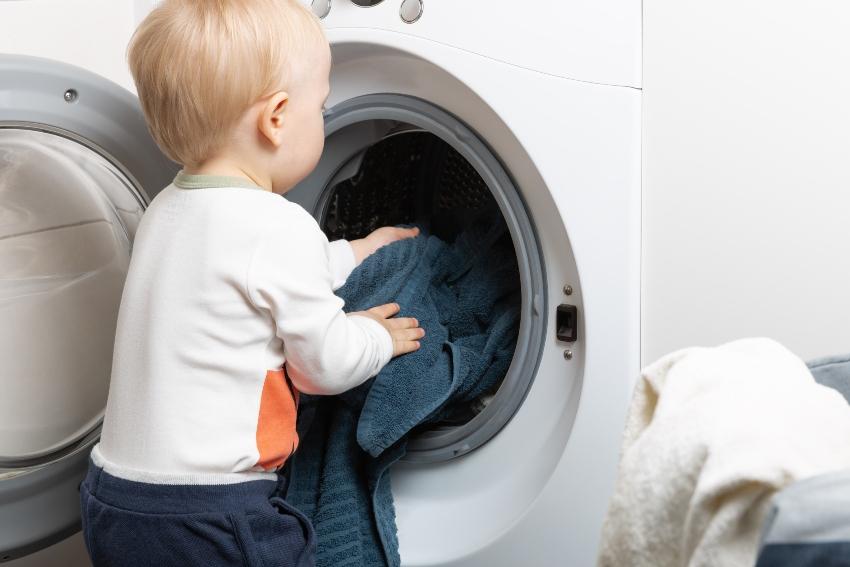 Baby vor der Waschmaschine