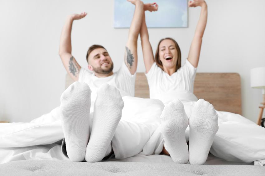 Mit Socken schlafen : Junges Paar wacht im Bett auf 