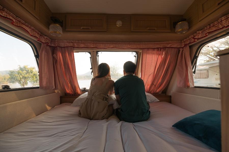 Paar sitzt im Wohnmobil im Bett - Matratzengrößen