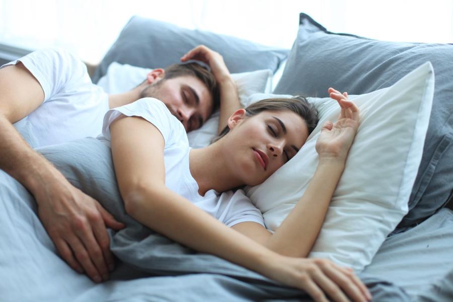 Junges Paar liegt schlafend im Bett