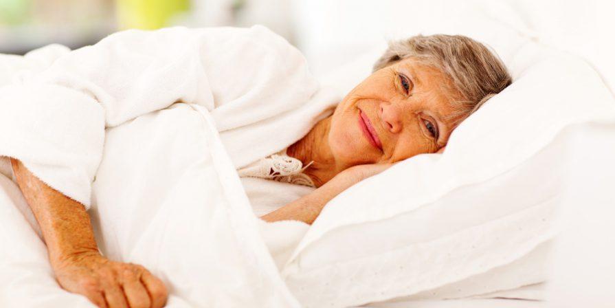Seniorin im Bett - Inkontinenz-Matratzenauflagen