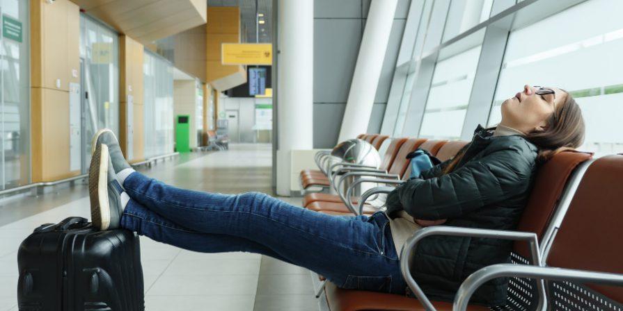 Frau schläft am Flughafen - Jetlag vermeiden