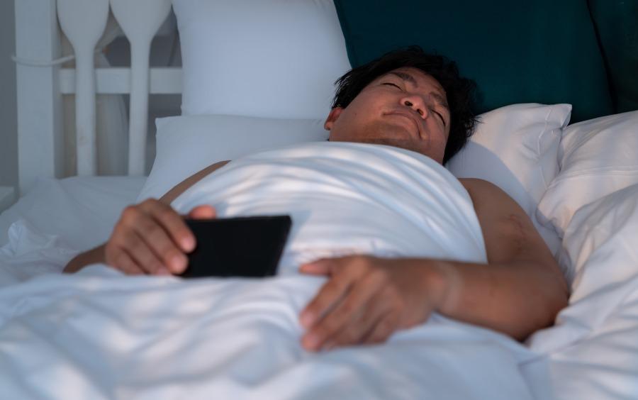 Übergewichtiger Mann schläft im Bett - Welche Matratzenart ist die beste?