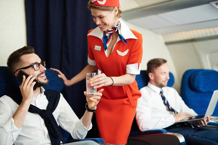 Mann bekommt Wasser von Stewardess