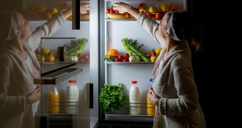 Frau nachts am Kühlschrank - Wann und was vor dem Schlafen essen?