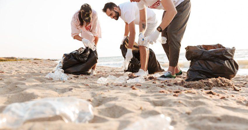 Junge Leute sammeln Plastik am Strand - Matratzen: ökologisch und umweltfreundlich