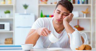 Junger Mann müde beim Frühstück - Schlafrhythmus umstellen