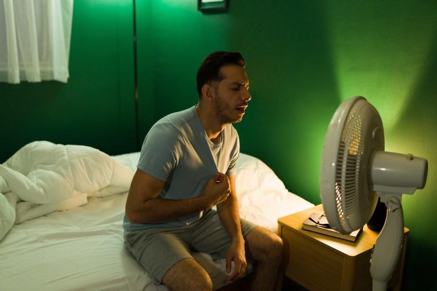 Mann sitzt nachts vor Ventilator