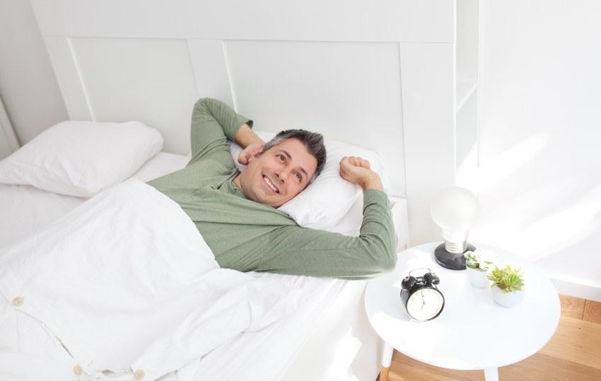 Mann wacht morgens fröhlich auf - Matratzentypen im Vergleich