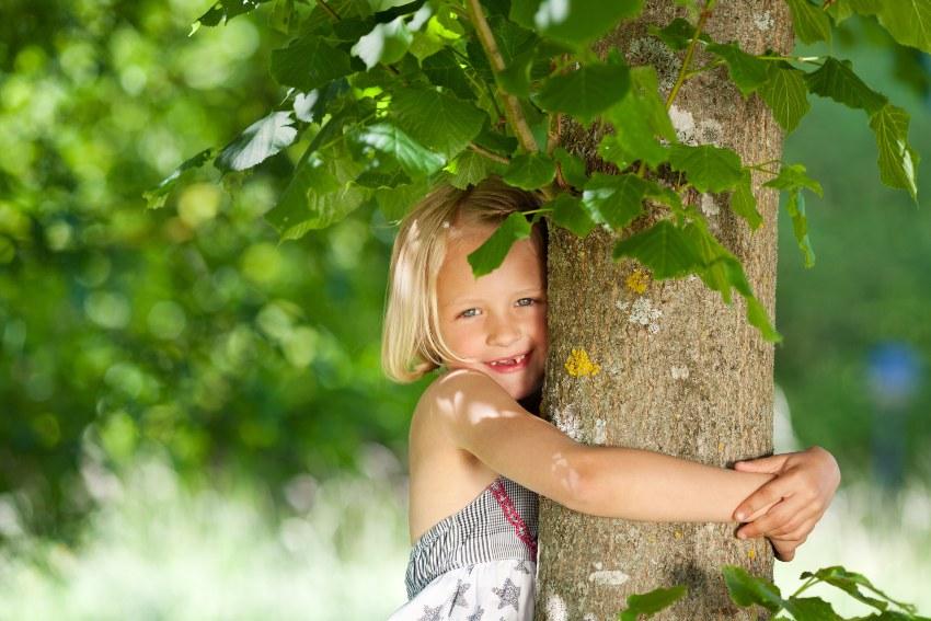 Mädchen umarmt Baum