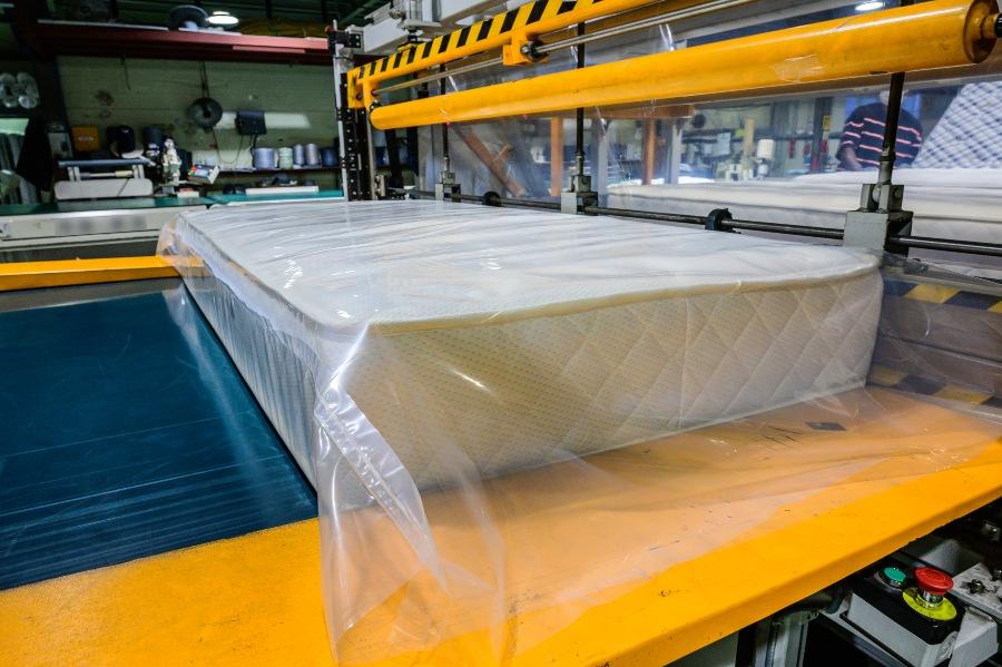 Matratze lieg in einer Maschine, bereit für die Vakuumierung - Matratze transportieren beim Umzug