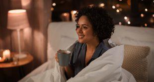 Junge Frau trinkt Kaffee im Bett - Koffein vor dem Schlafen vermeiden