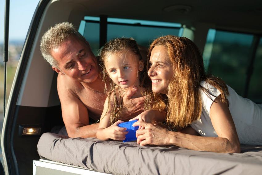 Junge Familie liegt hinten im Auto/ Wohnmobil