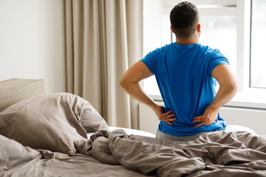 Mann-mit-Rueckenschmerzen-im-Bett - passende Matratze für mein Körpergewicht