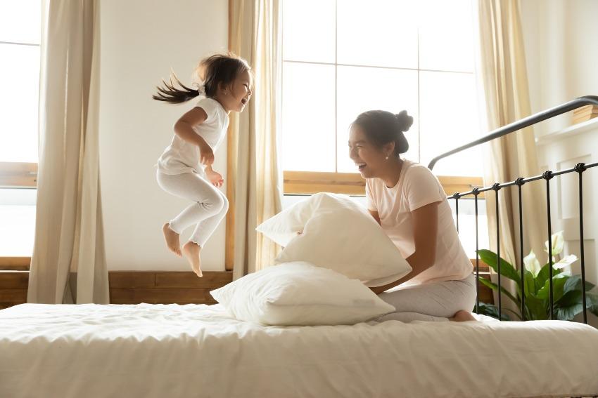 Mädchen und Mutter spielen im Bett - passende Matratze für mein Körpergewicht